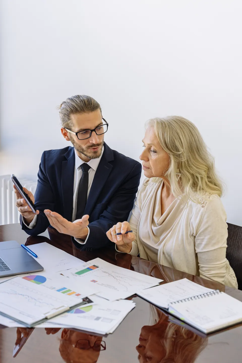 Two professionals reviewing financial documents in an office.